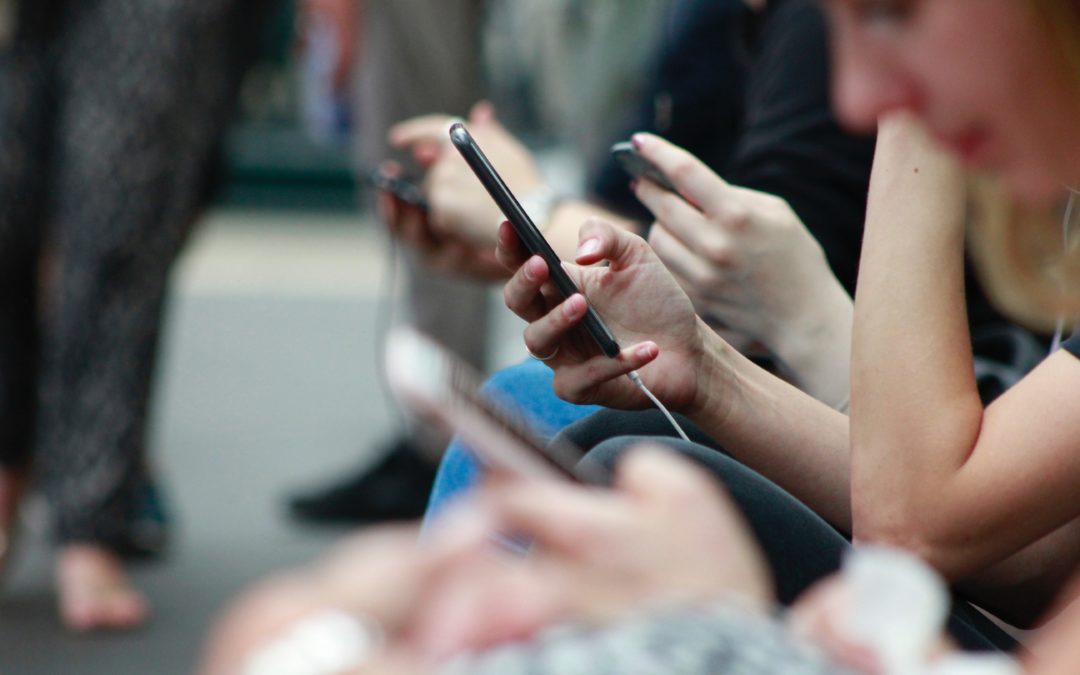 People sitting down holding mobile devices